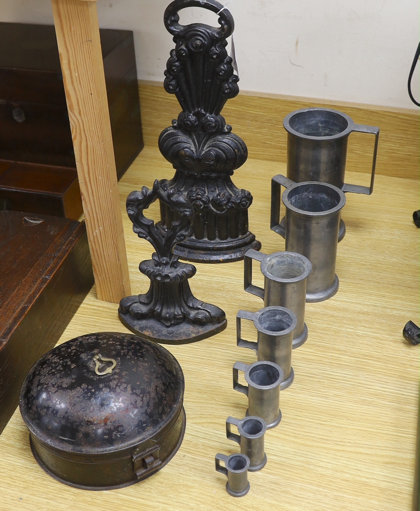 A graduated set of seven French pewter measures, a toleware spice box and two cast iron door stops (10), tallest door stop 39cms high